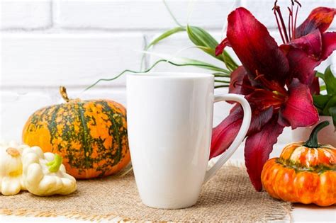 Download White coffee cappuccino mug mockup with pumpkin and red lily.